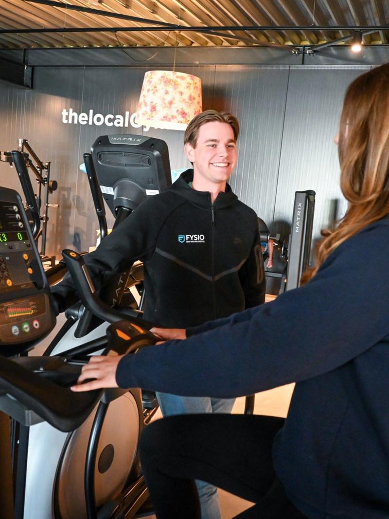 Fysiotherapeut voert fitness oefening uit met patiënt.